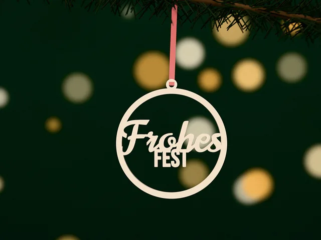Weihnachtsanhänger im Kreis mit „Frohes Fest“ in Weiß, hängt an einem roten Band an einem Tannenzweig mit Lichtern